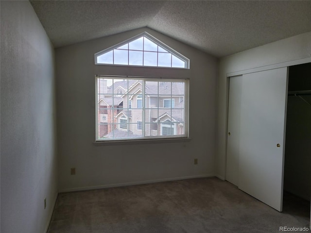 4760 S Wadsworth Unit 301, Littleton, CO 80123 - unfurnished bedroom with carpet flooring, vaulted ceiling, multiple windows, a closet, and a textured ceiling