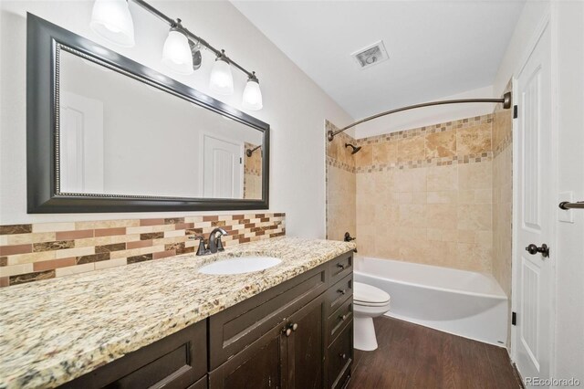 3806 S Yosemite St, Denver, CO 80237 - full bathroom with vanity, wood finished floors, backsplash, toilet, and shower / bath combination