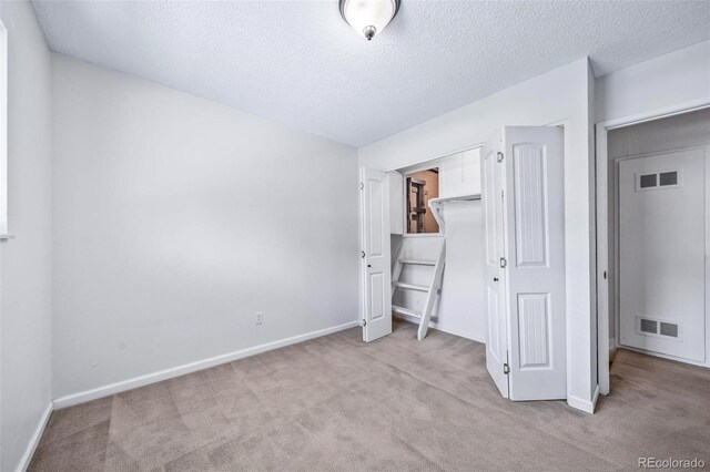 3806 S Yosemite St, Denver, CO 80237 - unfurnished bedroom with carpet flooring, baseboards, a textured ceiling, and a closet