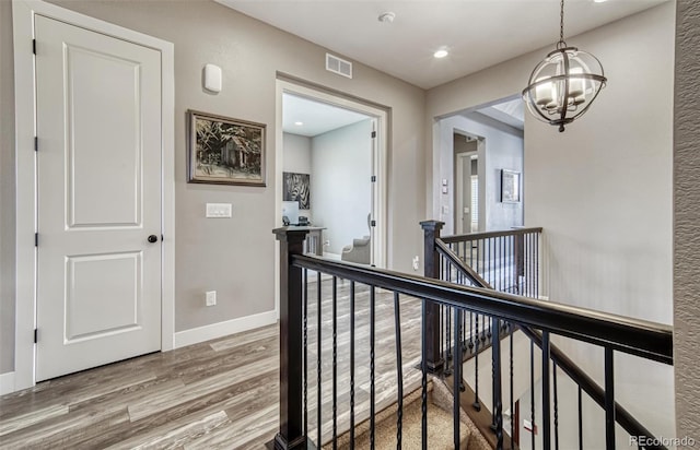 15804 Elizabeth Cir E, Thornton, CO 80602 - hall featuring an upstairs landing, wood finished floors, a chandelier, baseboards, and recessed lighting