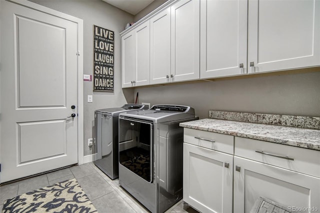 15804 Elizabeth Cir E, Thornton, CO 80602 - laundry room featuring washer and dryer, cabinet space, light tile patterned flooring, and baseboards