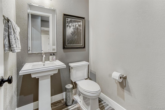 15804 Elizabeth Cir E, Thornton, CO 80602 - bathroom featuring wood finished floors, toilet, a textured wall, and baseboards