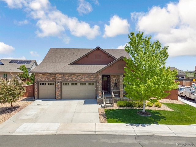 15804 Elizabeth Cir E, Thornton, CO 80602 - view of front facade with driveway, an attached garage, roof with shingles, and stone siding