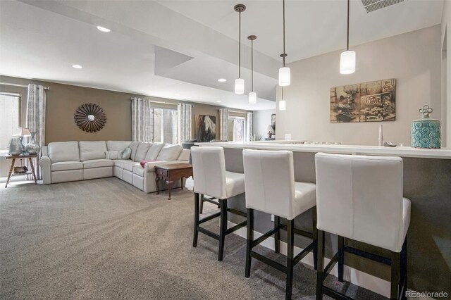 15804 Elizabeth Cir E, Thornton, CO 80602 - kitchen featuring carpet floors, recessed lighting, a breakfast bar, and decorative light fixtures