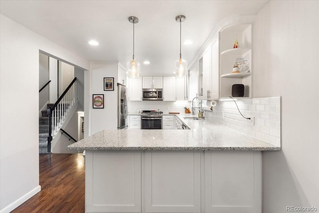 10833 W 61st Ave, Arvada, CO 80004 - kitchen featuring appliances with stainless steel finishes, open shelves, a peninsula, backsplash, and white cabinets