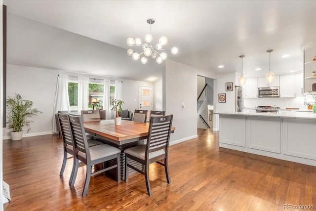 10833 W 61st Ave, Arvada, CO 80004 - dining room featuring dark wood-style flooring, a chandelier, recessed lighting, and stairway