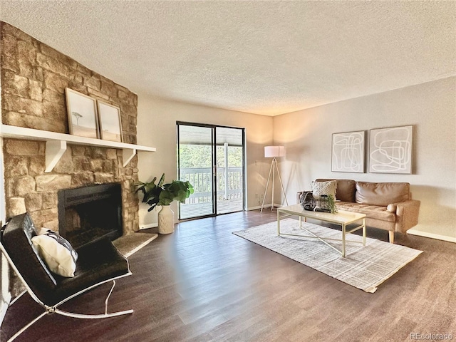 living area featuring a textured ceiling, a fireplace, baseboards, and dark wood-style flooring