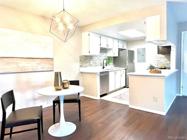 kitchen with stainless steel dishwasher, dark wood-style flooring, freestanding refrigerator, backsplash, and light countertops