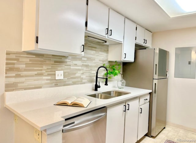 kitchen featuring stainless steel dishwasher, a sink, electric panel, freestanding refrigerator, and backsplash