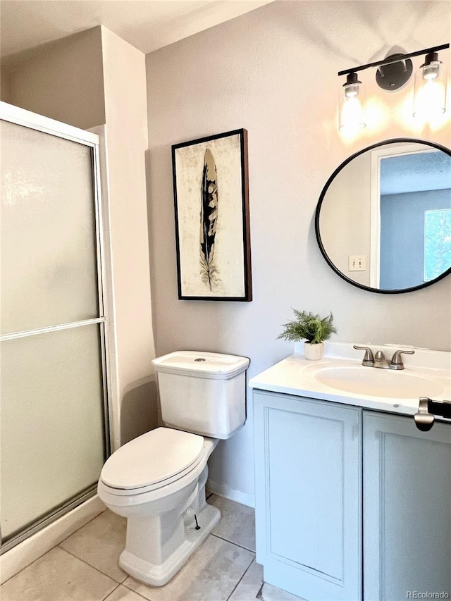 bathroom featuring tile patterned floors, vanity, a stall shower, and toilet