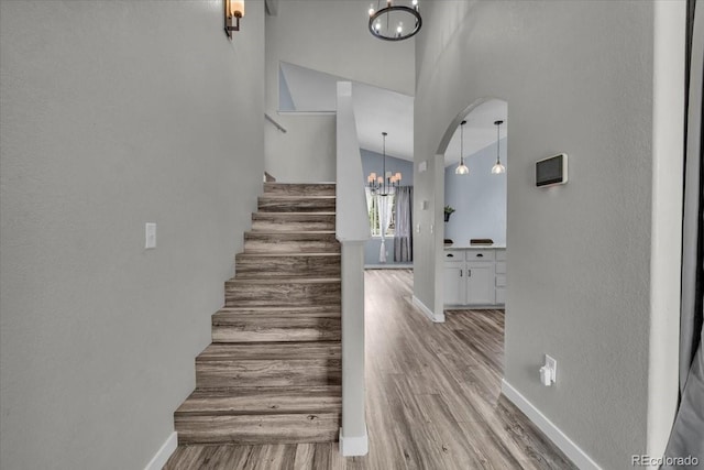 5286 Rustic Ave, Firestone, CO 80504 - staircase with a chandelier, baseboards, wood finished floors, and a high ceiling