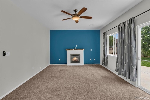 5286 Rustic Ave, Firestone, CO 80504 - unfurnished living room featuring ceiling fan, a glass covered fireplace, carpet floors, and baseboards