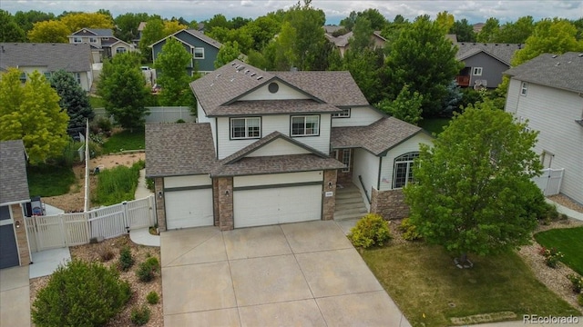 5286 Rustic Ave, Firestone, CO 80504 - traditional home featuring driveway, a gate, a garage, a shingled roof, and a residential view
