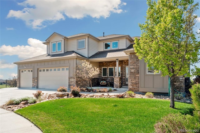 5954 Black Lion Ct, Windsor, CO 80550 - view of front of house featuring board and batten siding, covered porch, concrete driveway, a front lawn, and stone siding