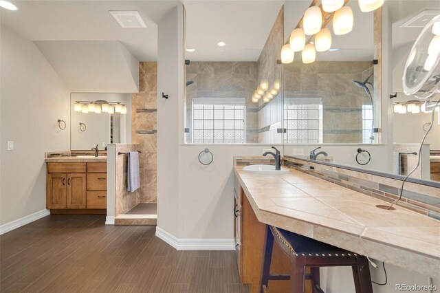 5954 Black Lion Ct, Windsor, CO 80550 - bathroom featuring walk in shower, baseboards, two vanities, healthy amount of natural light, and recessed lighting