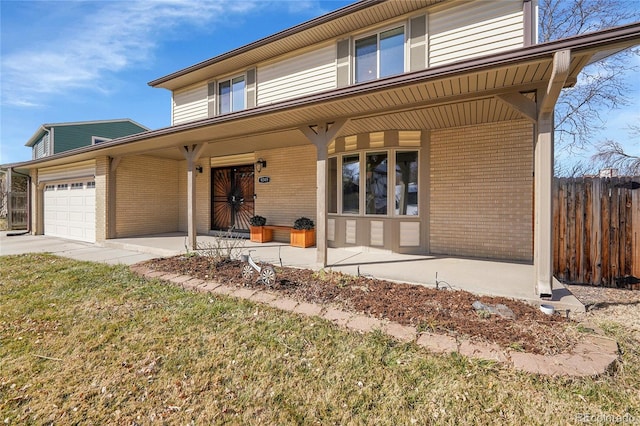 view of front of property featuring a front yard, fence, a porch, a garage, and brick siding