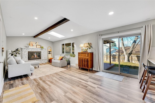 living area with lofted ceiling with beams, recessed lighting, wood finished floors, and a fireplace