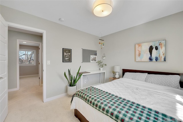 bedroom with baseboards and light carpet