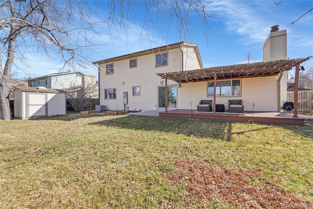 rear view of property featuring a storage unit, a lawn, a pergola, fence, and an outdoor structure