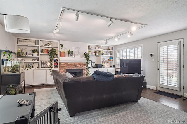 1295 S Downing St, Denver, CO 80210 - living room featuring track lighting, wood finished floors, and a brick fireplace