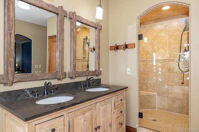 full bath featuring a sink, double vanity, and a shower stall