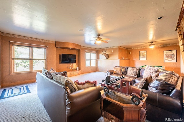 carpeted living room featuring baseboards and ceiling fan