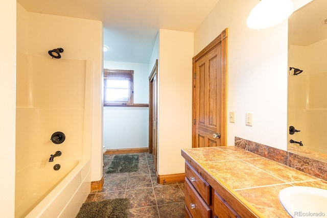 full bathroom featuring toilet, vanity, shower / bath combination, and baseboards