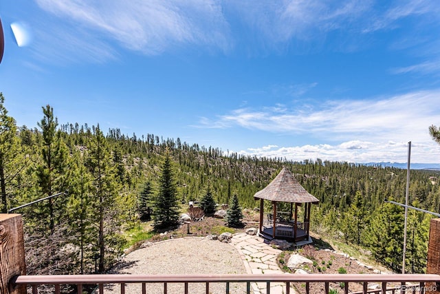 exterior space featuring a gazebo and a forest view