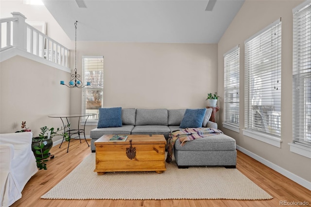 living room featuring plenty of natural light, high vaulted ceiling, and wood-type flooring