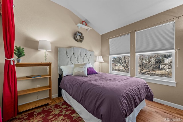 bedroom with lofted ceiling and light wood-type flooring