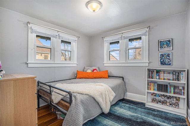 bedroom with dark wood-type flooring and multiple windows