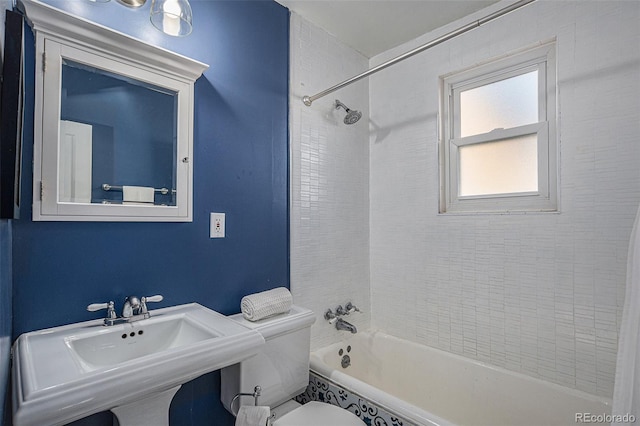 full bathroom featuring tiled shower / bath combo, sink, and toilet