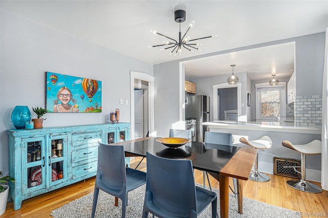 dining room with a chandelier and light wood-type flooring