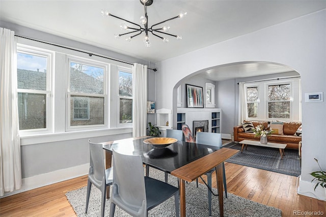 dining space featuring light wood-type flooring and a notable chandelier