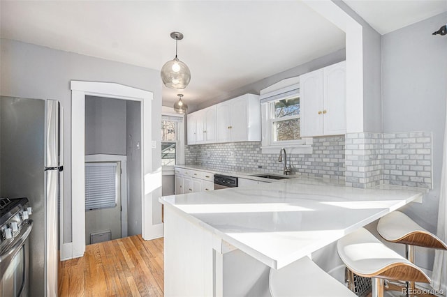 kitchen with pendant lighting, sink, kitchen peninsula, and white cabinets