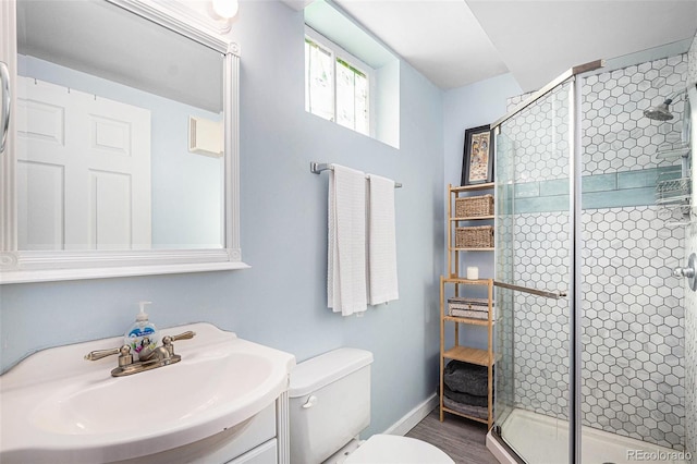 bathroom featuring vanity, toilet, a shower with shower door, and hardwood / wood-style floors