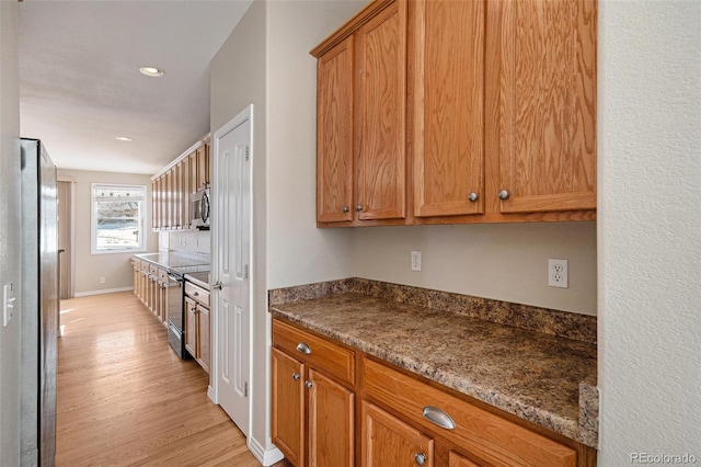 kitchen featuring stainless steel appliances, stone countertops, and light hardwood / wood-style floors