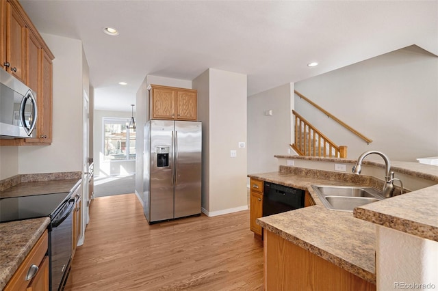 kitchen with a chandelier, appliances with stainless steel finishes, light hardwood / wood-style floors, and sink