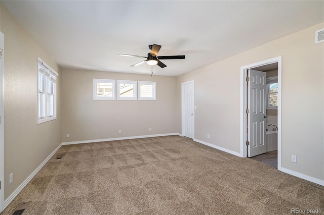 carpeted spare room with ceiling fan and plenty of natural light