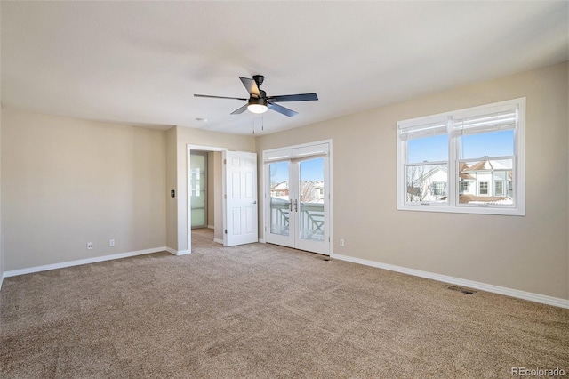 carpeted empty room featuring french doors and ceiling fan