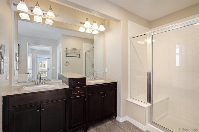 bathroom featuring vanity, an enclosed shower, and wood-type flooring