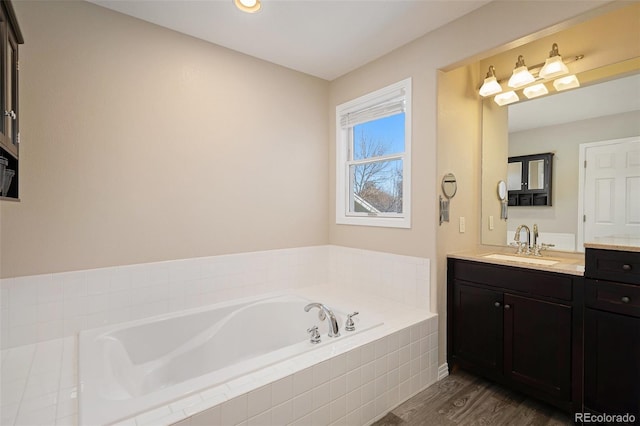 bathroom featuring vanity, a relaxing tiled tub, and hardwood / wood-style flooring