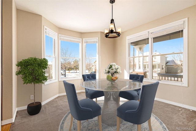 carpeted dining area with a chandelier