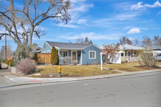 view of front of home featuring a front lawn, a porch, an attached garage, and fence