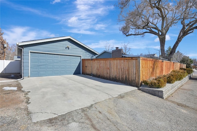 view of side of home with a garage and fence