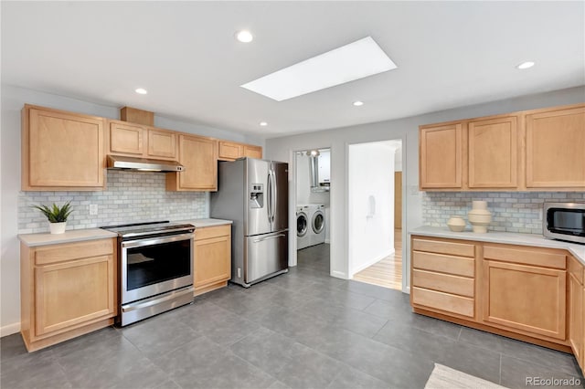 kitchen with washer and clothes dryer, stainless steel appliances, light countertops, and light brown cabinetry