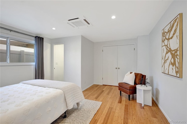 bedroom with light wood-style floors, baseboards, a closet, and recessed lighting