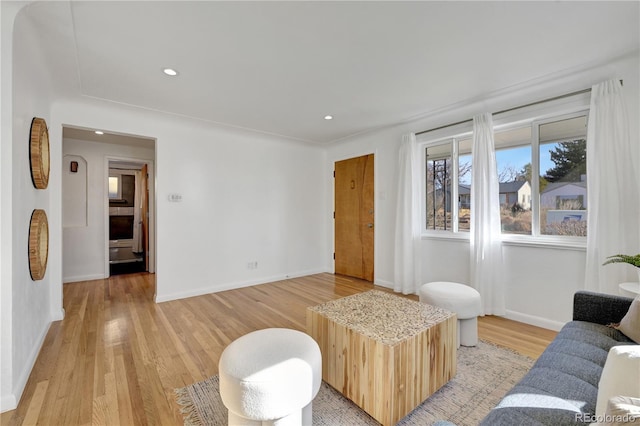 living area with light wood-style flooring, baseboards, and recessed lighting