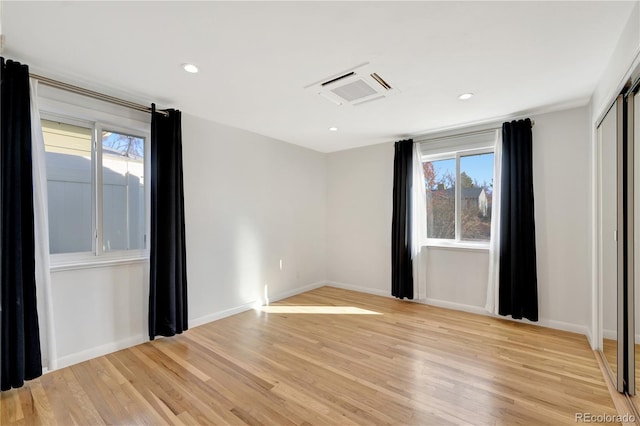 spare room with light wood finished floors, visible vents, baseboards, and recessed lighting