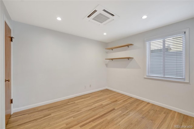 empty room with light wood-style floors, recessed lighting, and baseboards